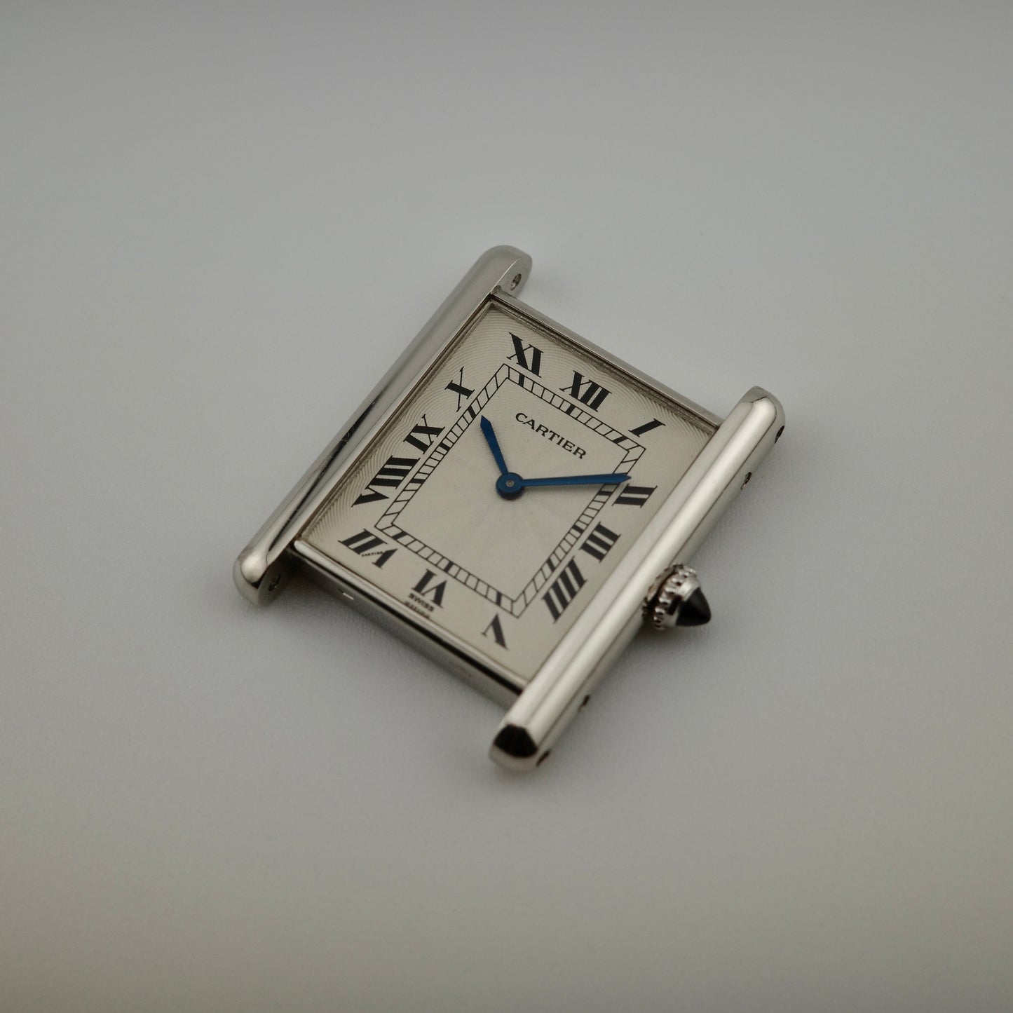 Silver Cartier watch on a gray background