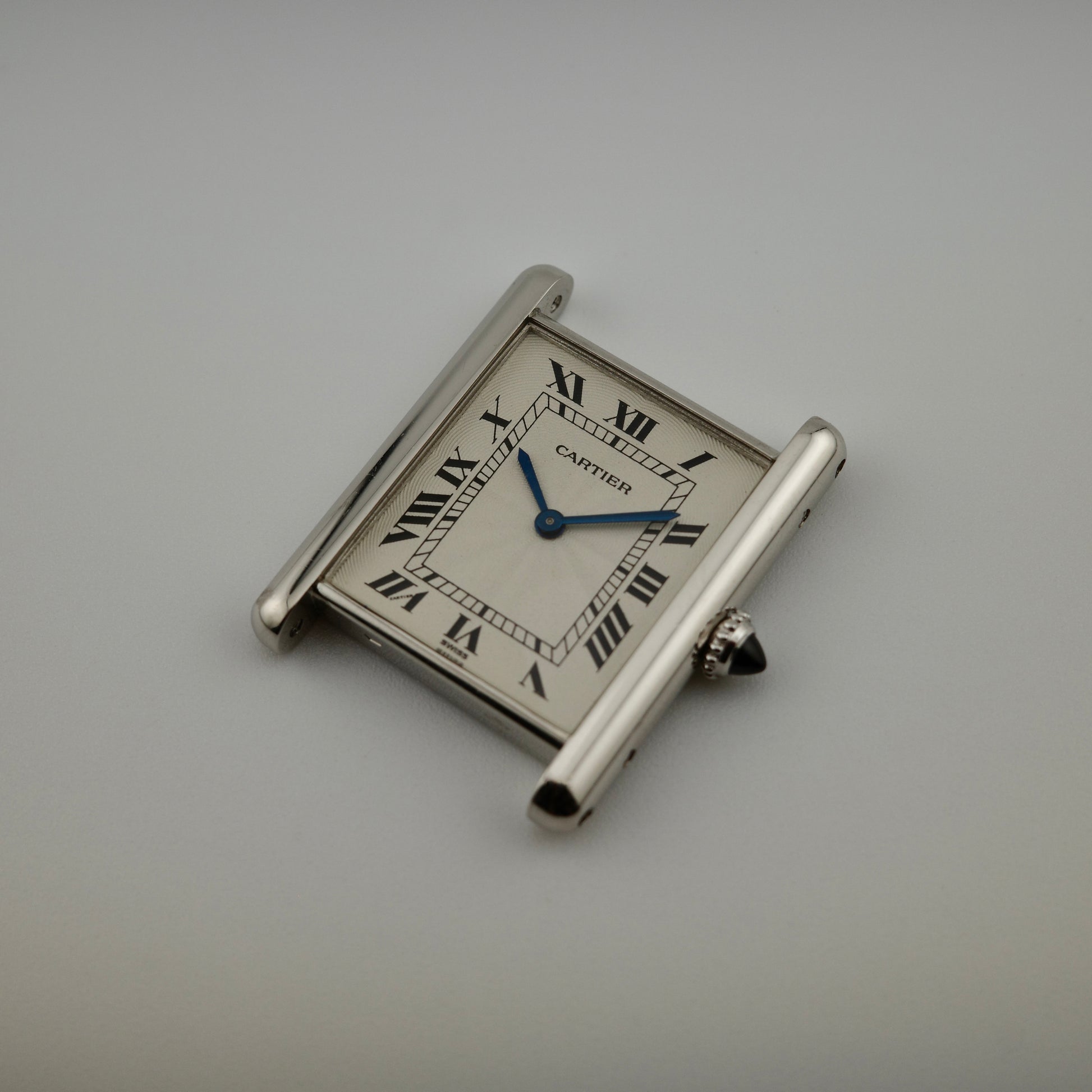 Silver Cartier watch on a gray background