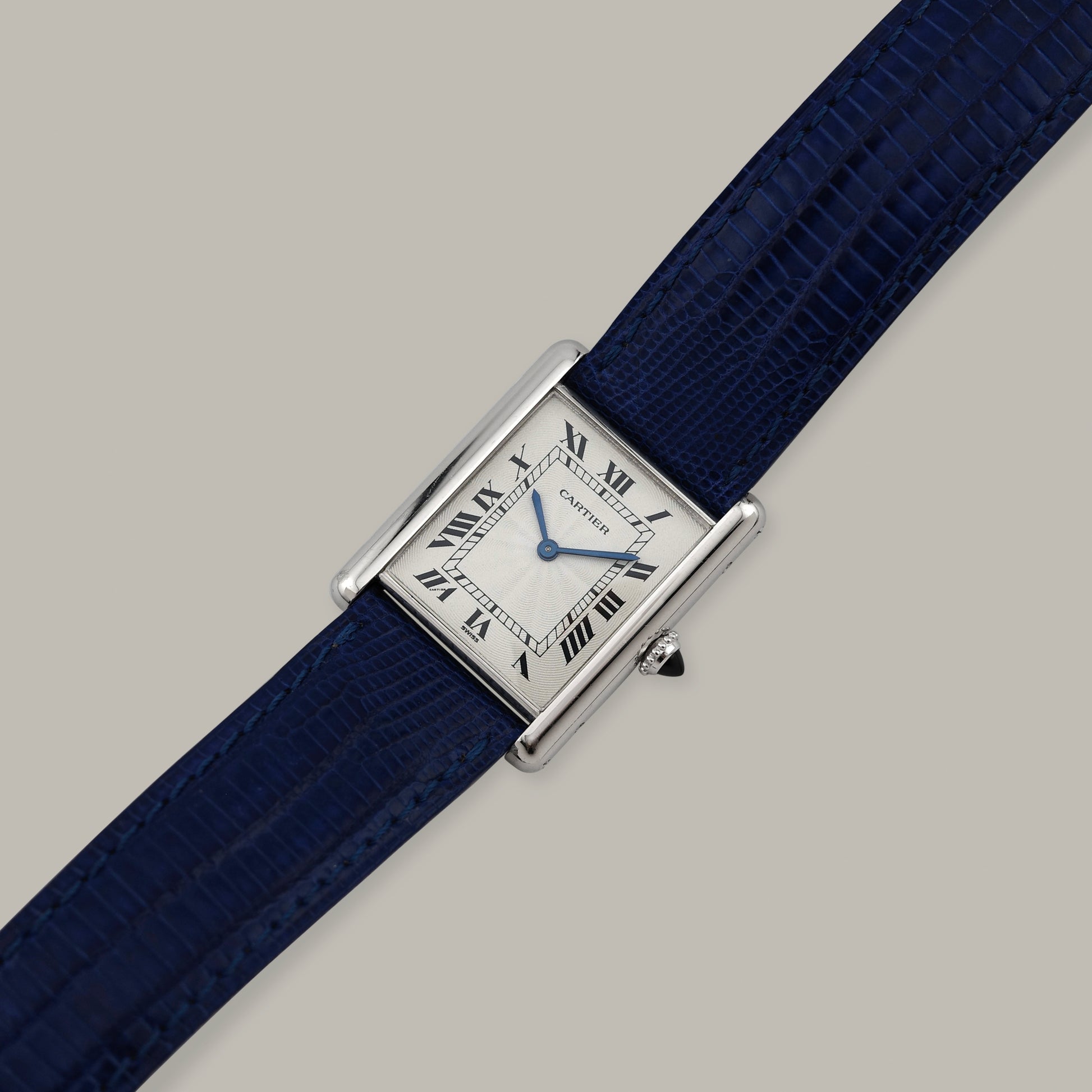 Cartier watch with blue strap on a gray background